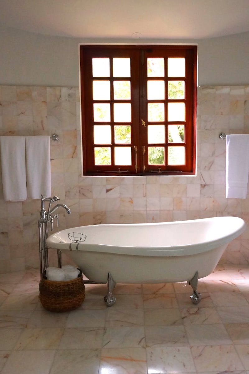 Luxurious bathroom featuring a classic freestanding bathtub and marble tiles.