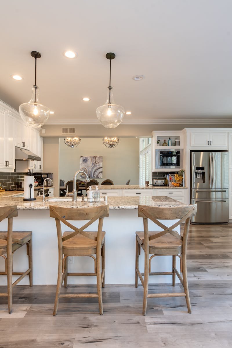 Bright and spacious kitchen interior featuring bar stools and modern design elements.